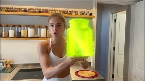 A woman in the same kitchen holding a glowing green jar