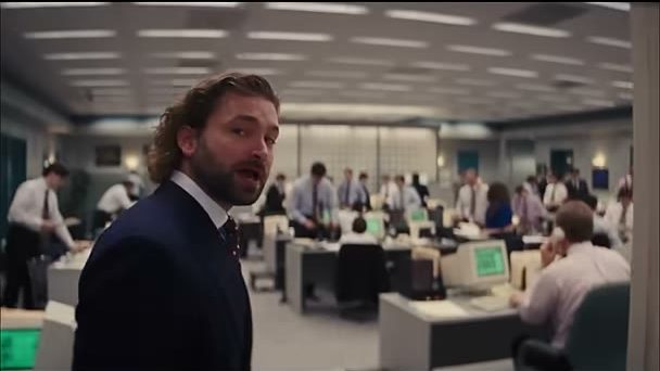 Rourke in a suit on a busy trading floor