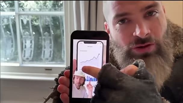 An older man with a long grey beard holding the same phone