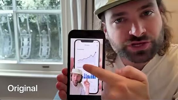 Rourke holding a phone with a chart up to the camera
